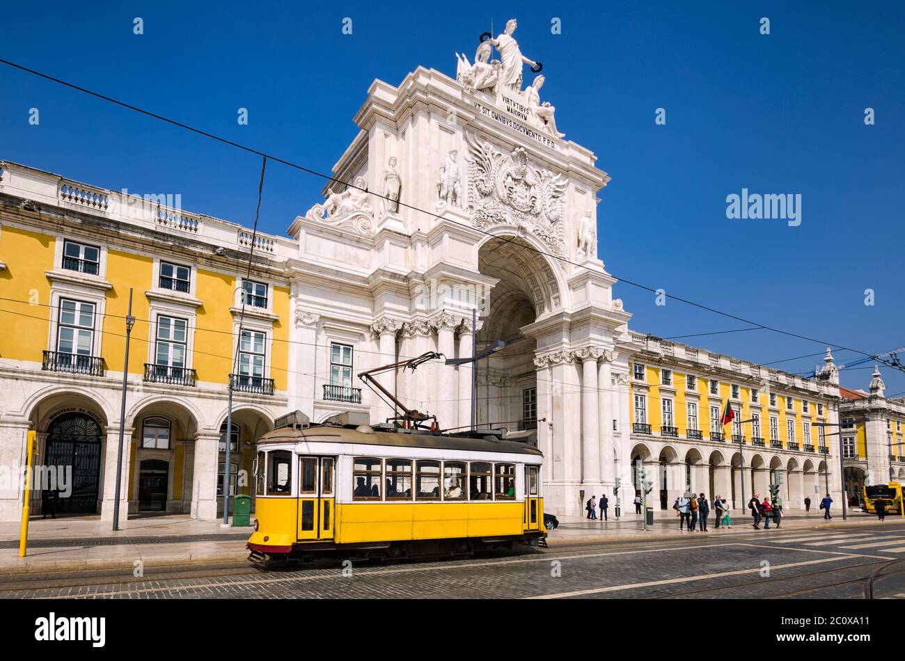 Historic yellow tram in front of Arco da Rua Augusta in Lisbon, Portugal Stock Photo
