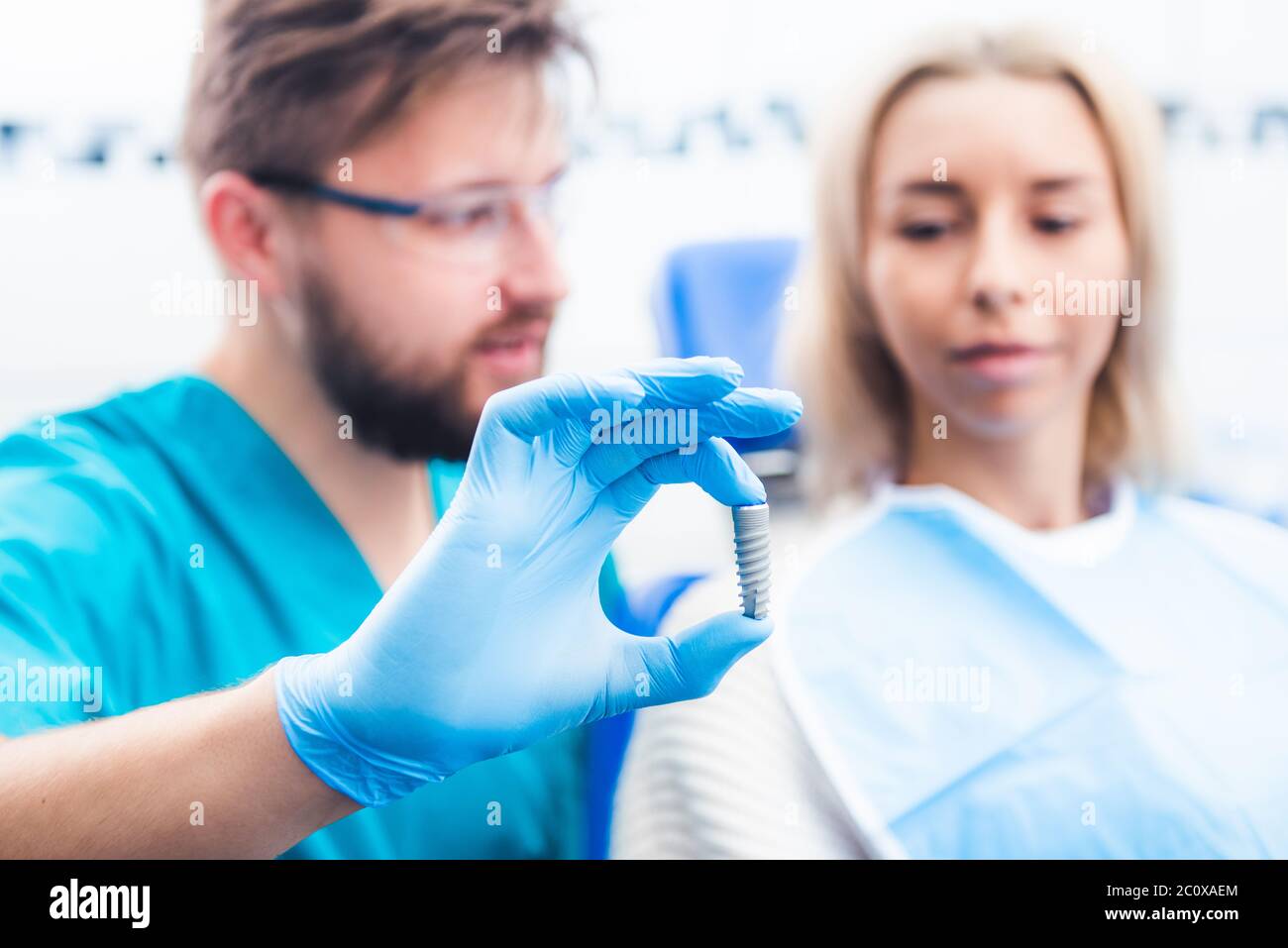 Dentist showing gray implant model to patient Stock Photo Alamy