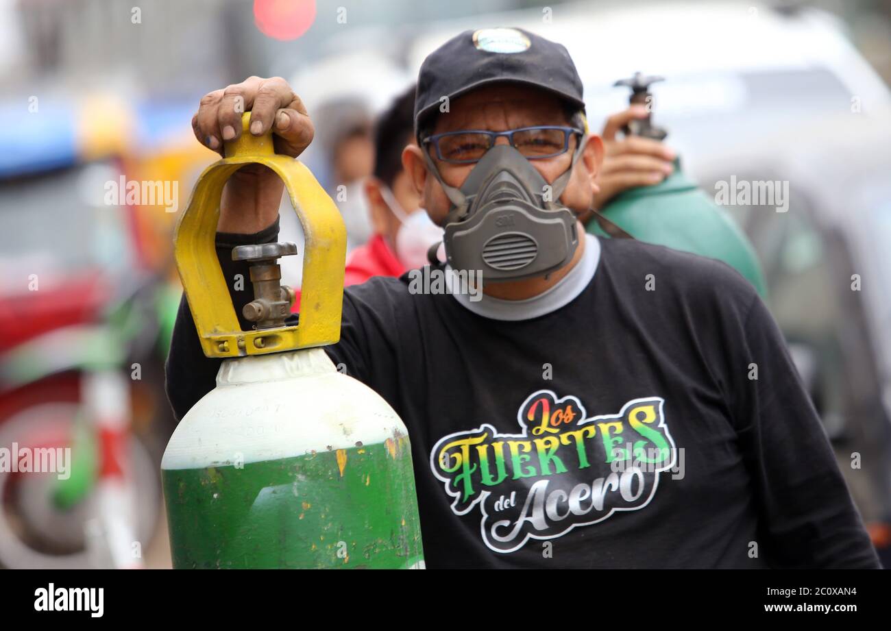 Lima, Peru. 12th June, 2020. A man wearing a 3M mouthguard is standing in a queue next to his oxygen bottle, which he wants to refill in the middle of the corona pandemic. In Peru, the second most affected country in South America by the corona pandemic, the government wants to increase oxygen production. Funds would also be made available for the import of oxygen. 'We regard oxygen as an element of national interest,' said Defence Minister Martos the other day. Credit: Cesar Lanfranco/dpa/Alamy Live News Stock Photo
