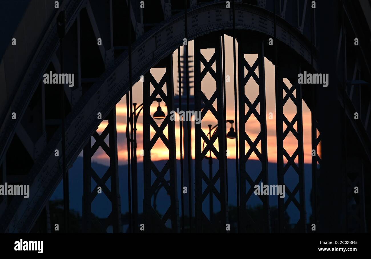 12 June 2020, Hessen, Frankfurt/Main: Behind the arch of the Honsellbrücke bridge at the Osthafen, the Frankfurt television tower, popularly known as 'Ginnheimer Spargel', can be seen at sunset. Photo: Arne Dedert/dpa Stock Photo