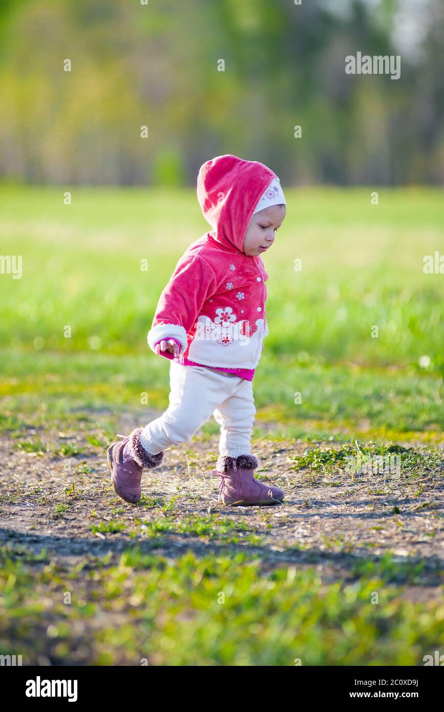 Happy little girl walking in the meadow and looking at sun Stock Photo ...
