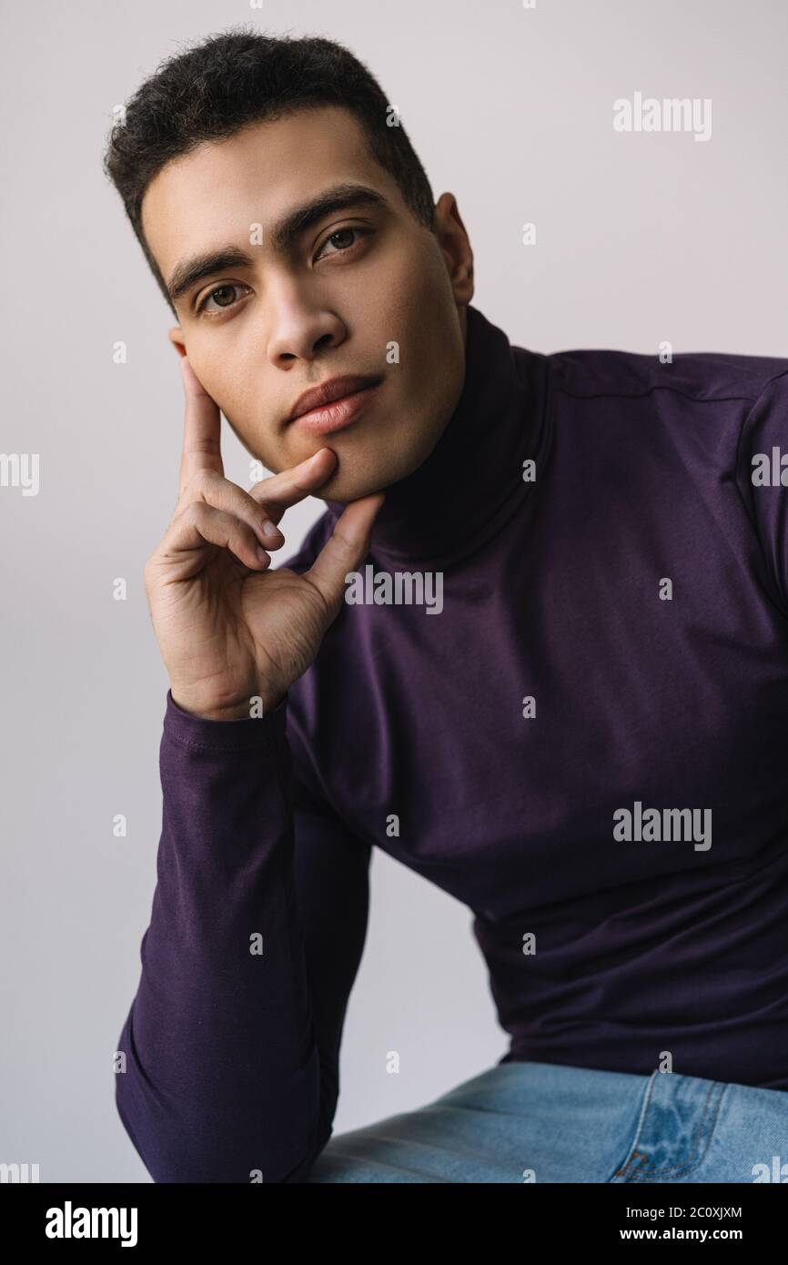Portrait of pensive man looking at camera. Handsome African American fashion model posing for pictures in studio isolated on background Stock Photo