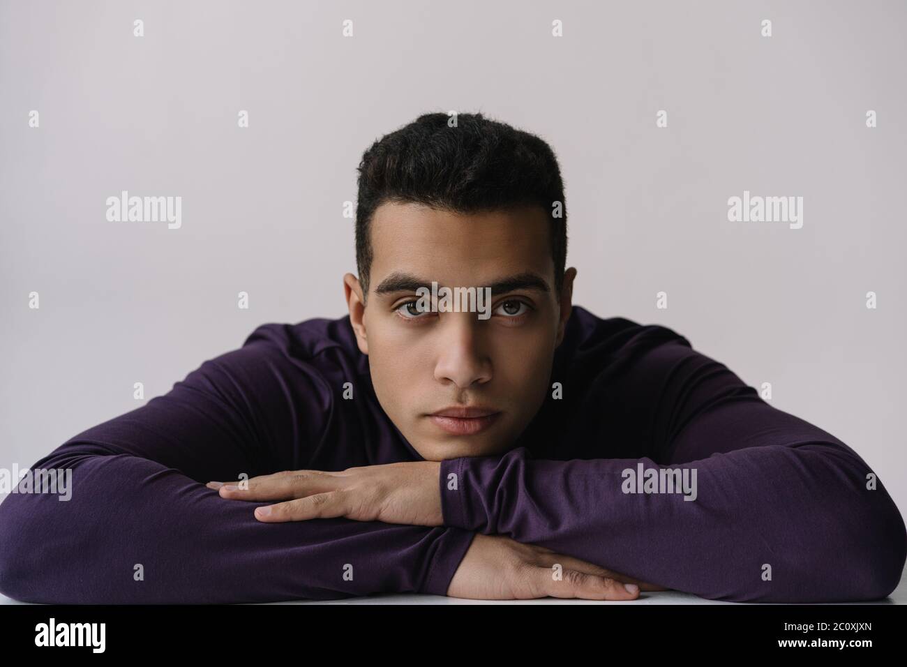 Portrait of serious African American actor posing for pictures in studio isolated on background. Model wearing stylish turtleneck looking at camera Stock Photo