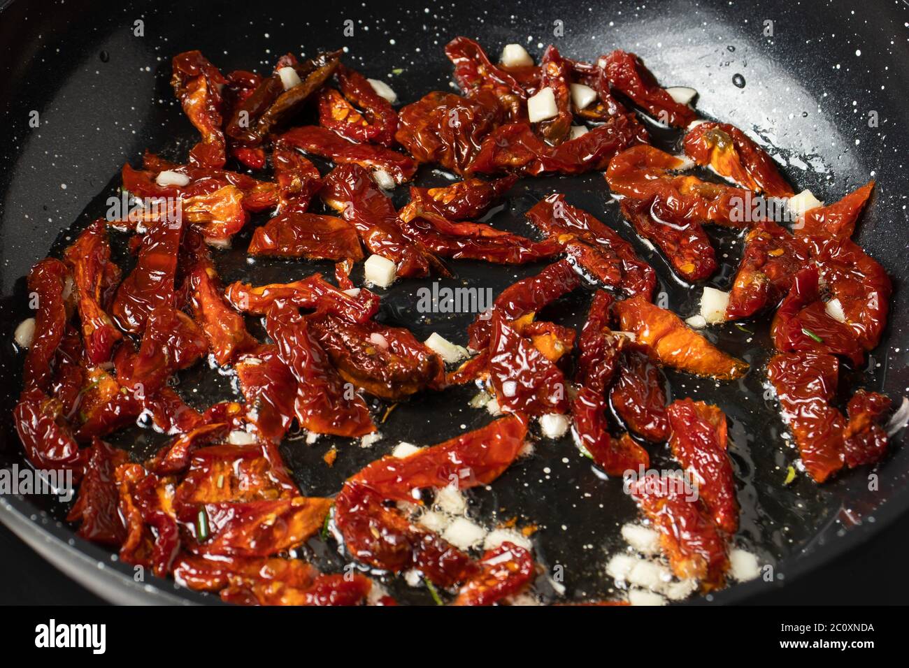 Panfried dried tomatoes with garlic and rosemary to make pasta sauce
