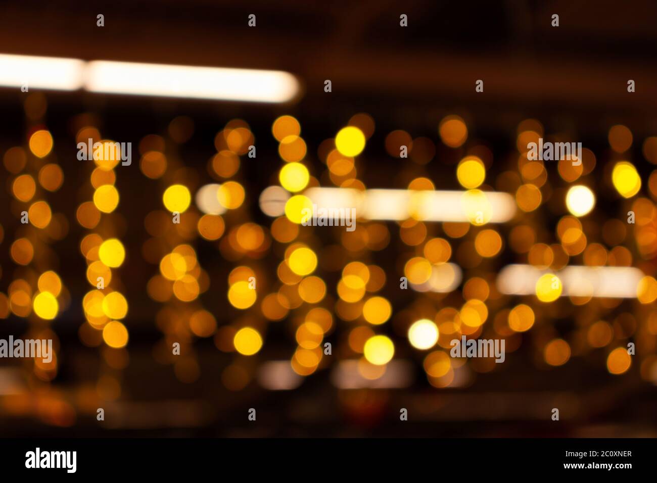 Blurry lights of urban Christmas illumination. Golden bokeh, abstract background. Stock Photo