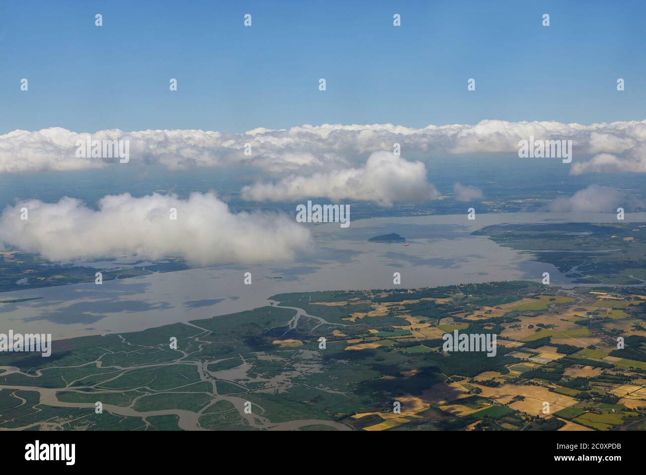 Airplane flying above landscape village trees fields classic blue sky over the rural Stock Photo