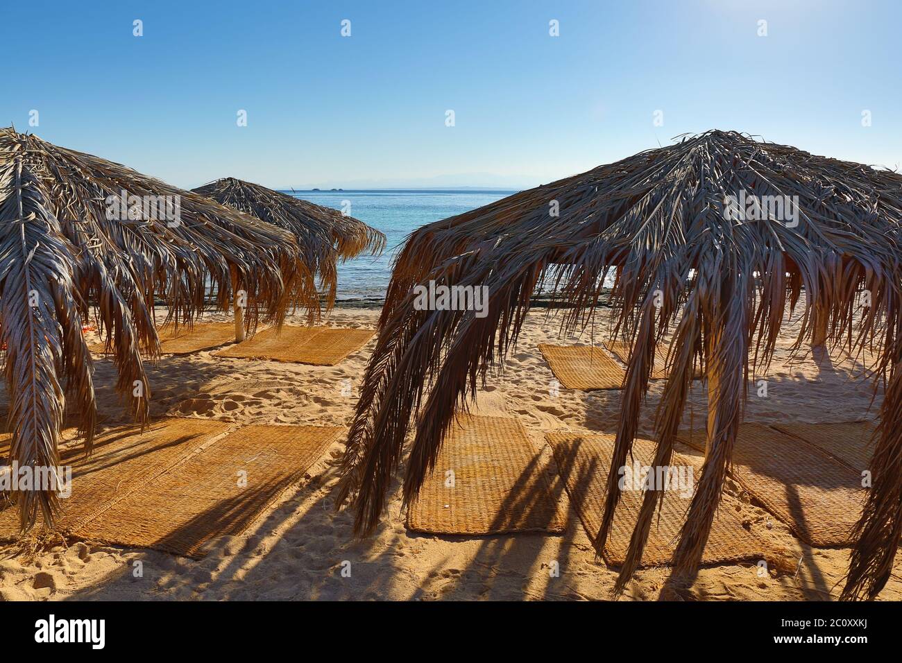 umbrellas and mats on beach Stock Photo Alamy