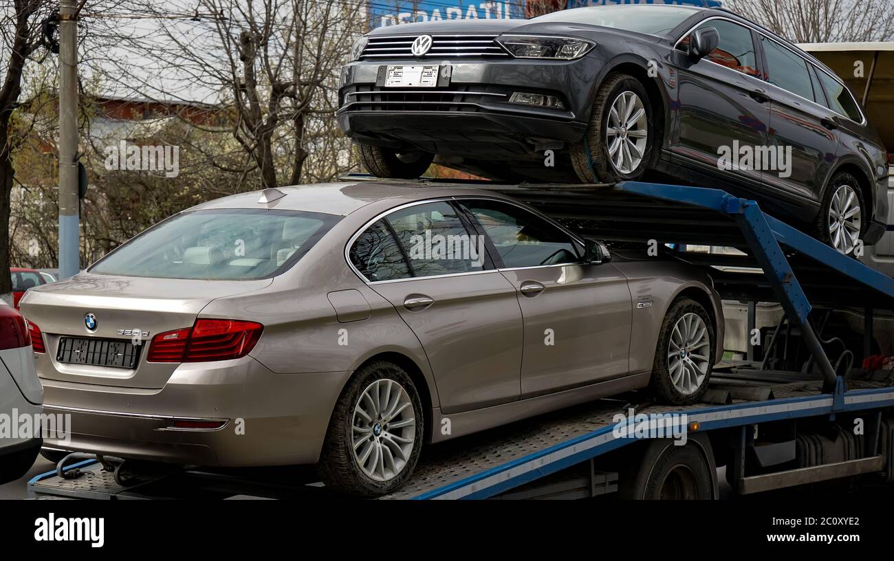 Bucharest, Romania - March 02, 2020: A BMW 520d car and a Volkswagen Passat B8 Highline Variant are transported on a trailer in Bucharest. Stock Photo
