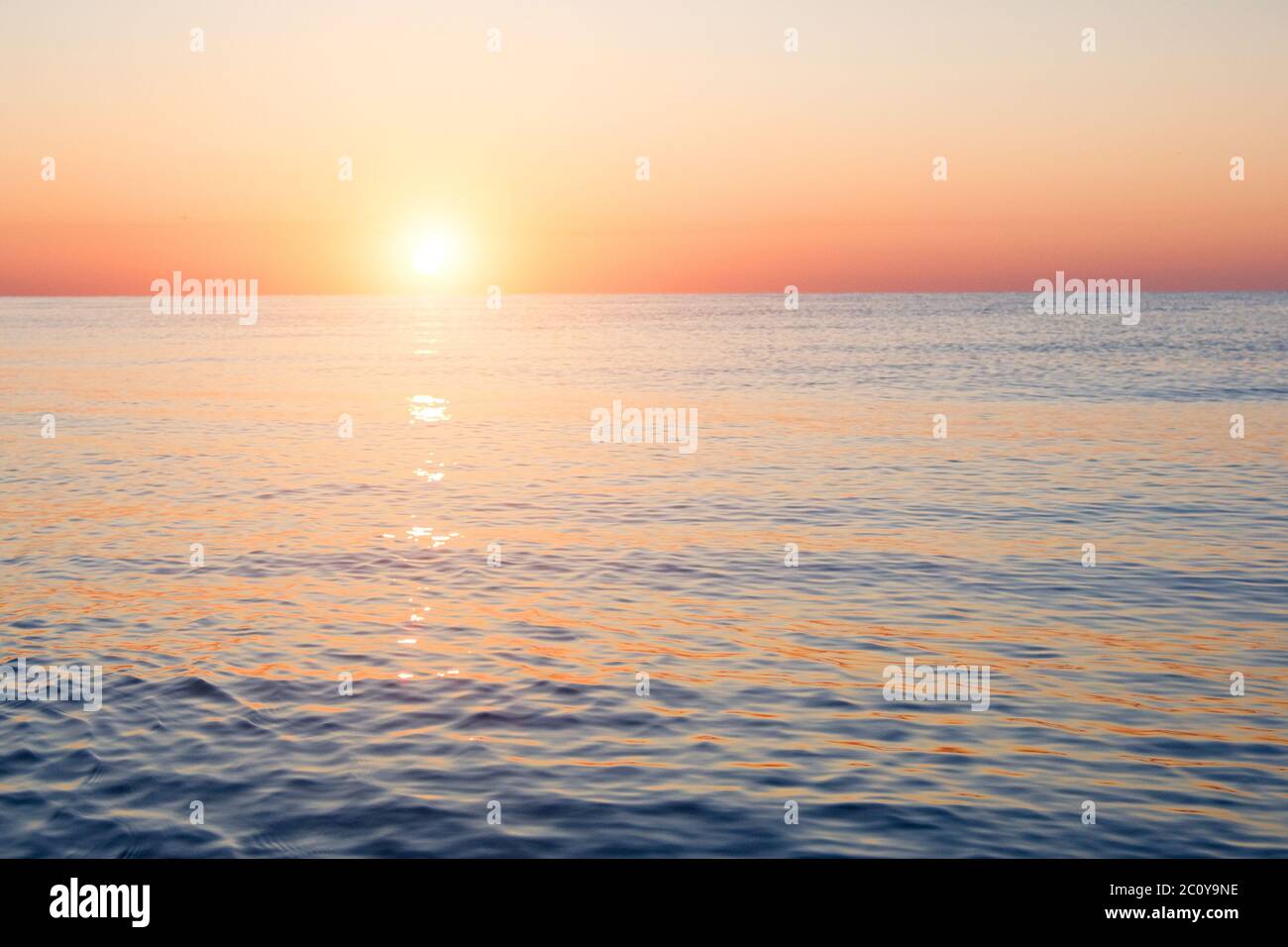 Bright sunset with large yellow sun under the sea surface Stock Photo