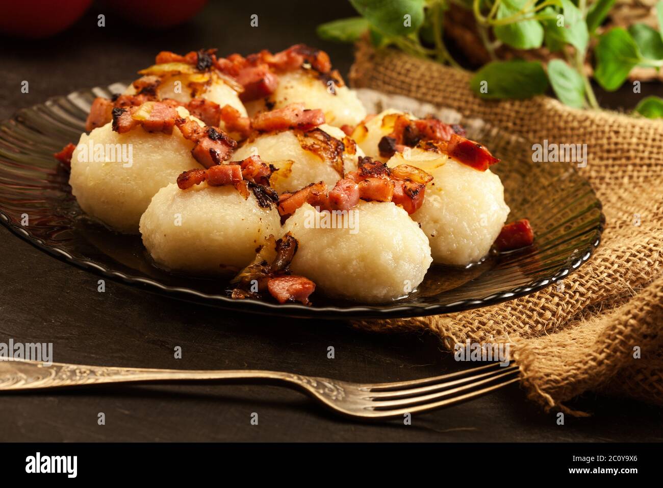 Potato dumplings stuffed with meat served with bacon on a plate Stock Photo