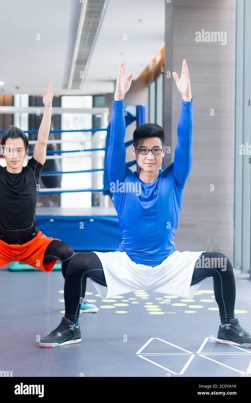 young asian boys doing yoga in modern gym Stock Photo