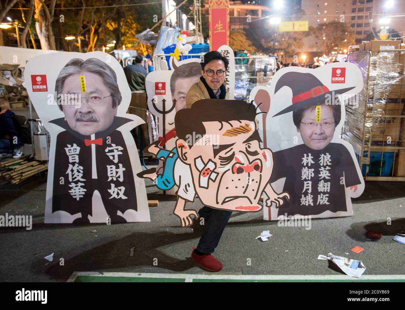 June 12, 2020, Hong Kong, Hong Kong, China: Alongside the Lunar New Year flower stalls, political parties also rent stalls to get their message across.Hong Kong politician and chairman of the League of Social Democrats (LSD), AVERY NG MAN-YUEN holds caricature cardboard cutouts of the candidates for the upcoming election for the Hong Kong Chief Executive.Each candidate is regarded as Pro-Beijing as the election only allows for democratic vote from a Beijing CCP pre-approved list.L to R John Tsang, C.Y.Leung (Leung Chun-ying) and Carrie Lam(as C.Y.Leung lookalike).Ng is holding C.Y.Leung. (Cre Stock Photo