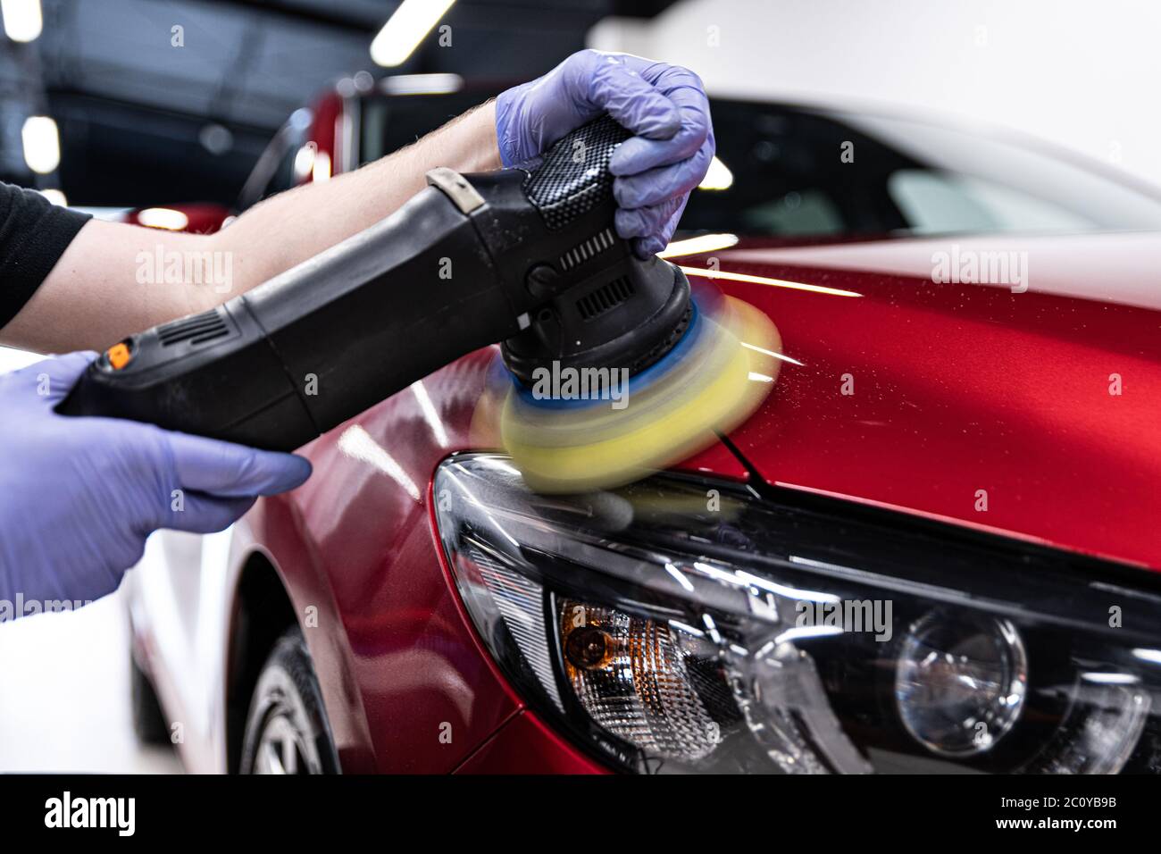 Man worker of car detailing studio polishing car varnish Stock Photo