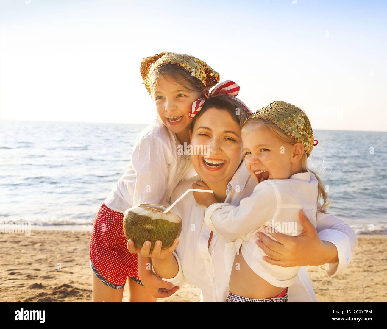 Mother and her daughters at tropical beach Stock Photo