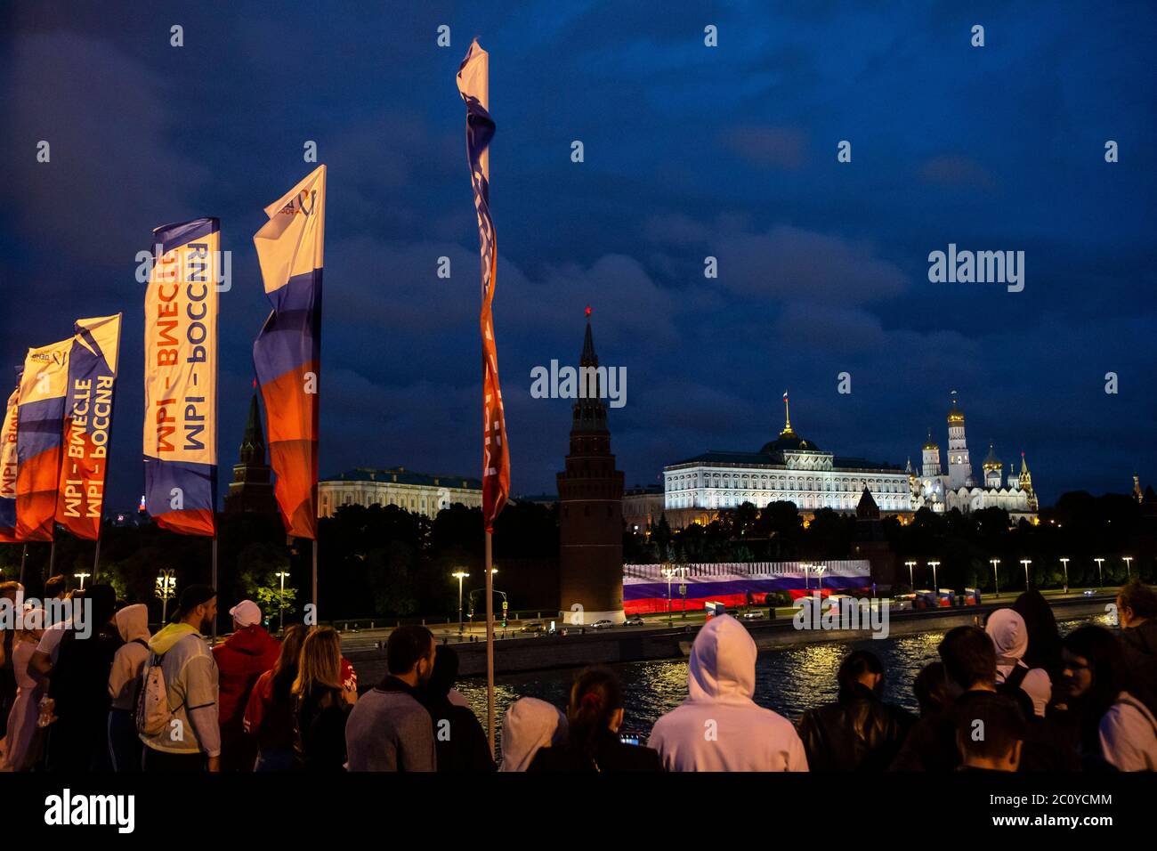 Moscow, Russia. 12th June, 2020. People watch Russian national flag projected on the Kremlin wall to celebrate Russia day in Moscow, Russia, on June 12, 2020. Credit: Alexander Zemlianichenko Jr/Xinhua/Alamy Live News Stock Photo