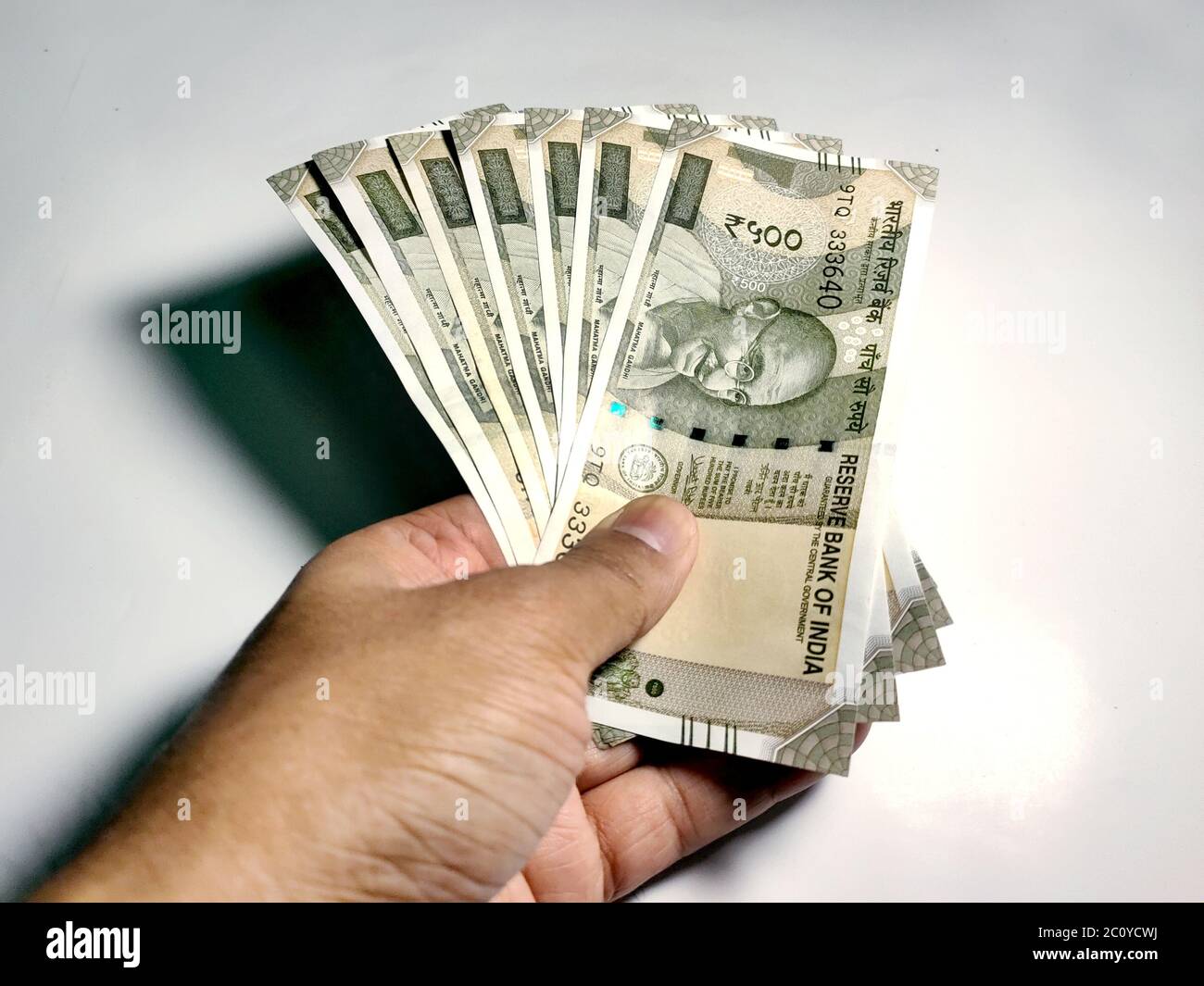 Hand holding five hundred Indian rupee notes against white background Stock Photo