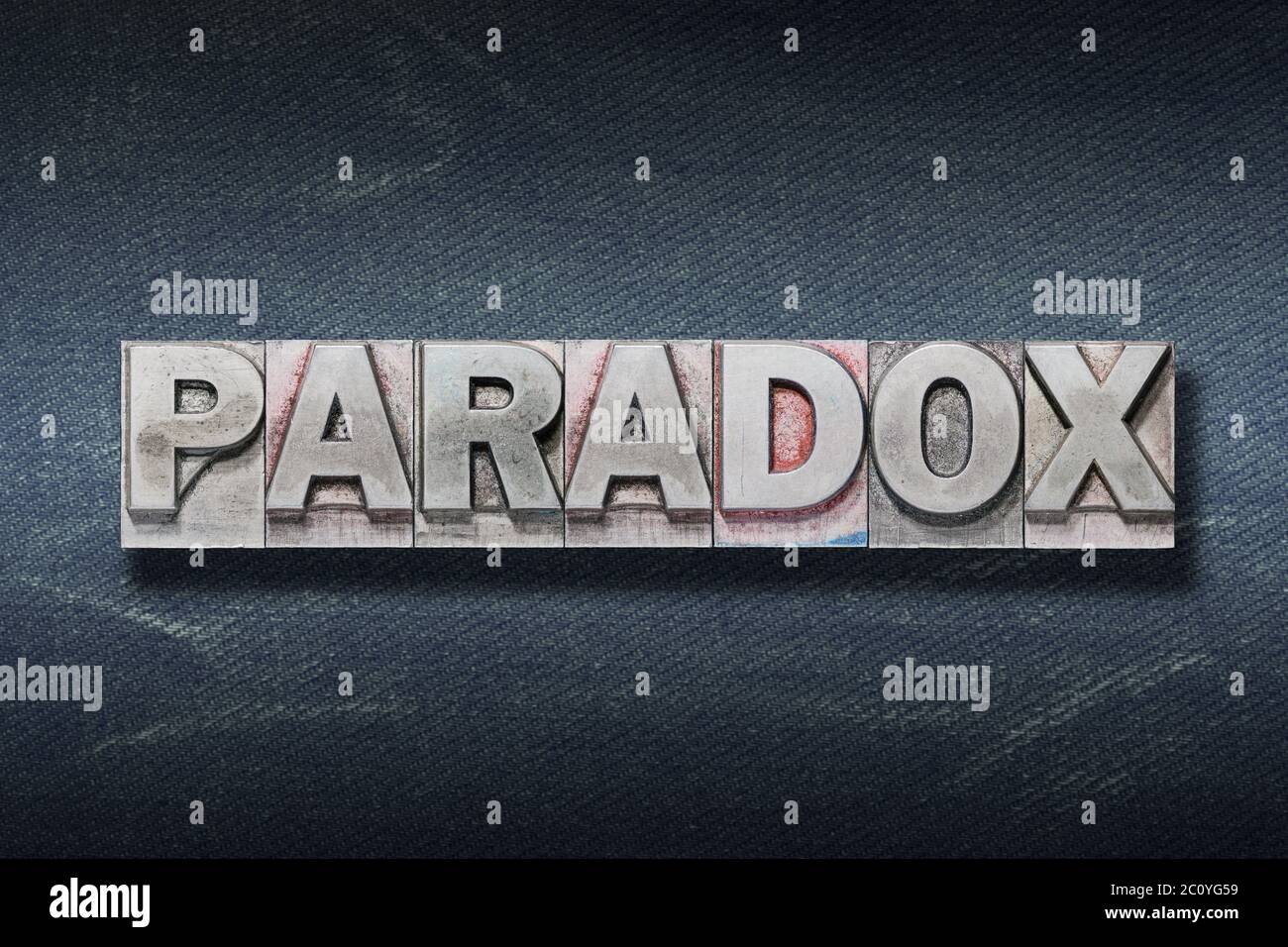 paradox word made from metallic letterpress on dark jeans background Stock Photo