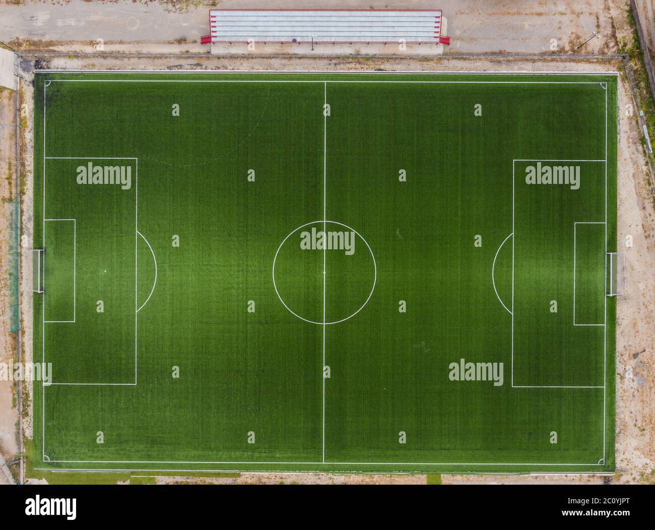 Top down drone view of a football field on the outskirts of a village