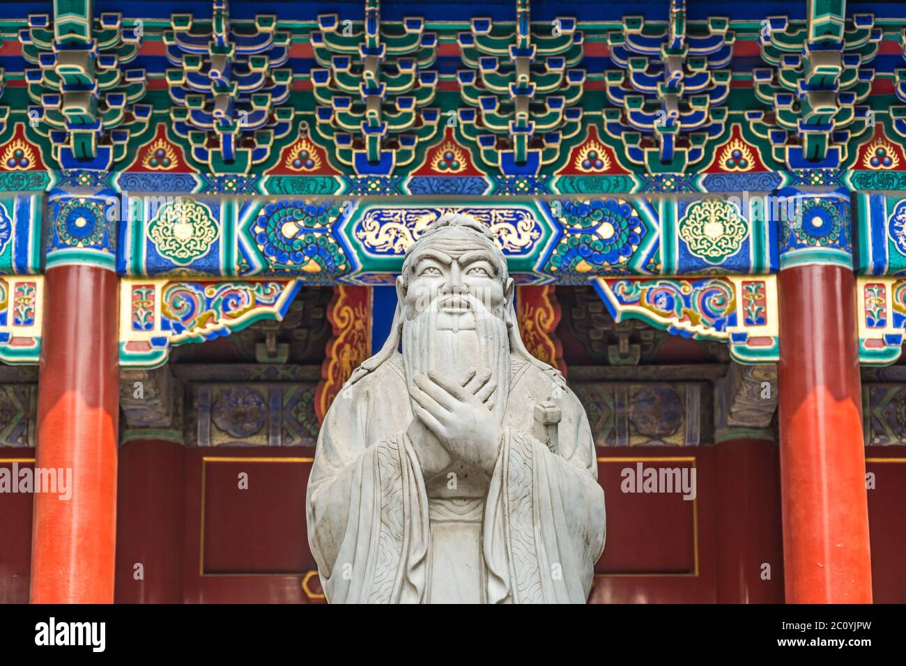 Confucius statue in front of colorful ancient temple with beautiful ornaments Stock Photo