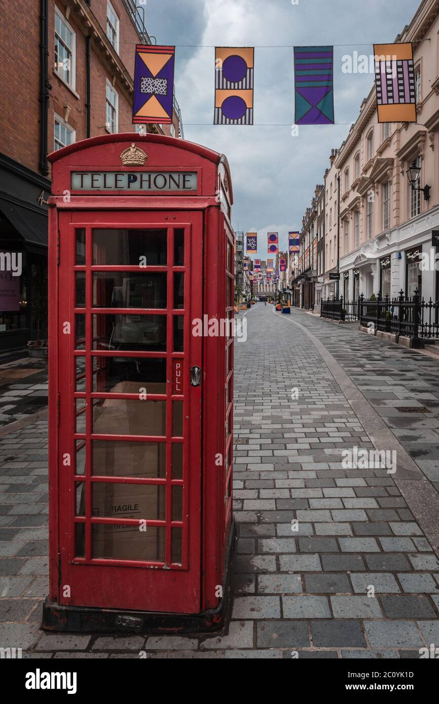 An iconic red telephone box on an empty famous street in Mayfair during ...