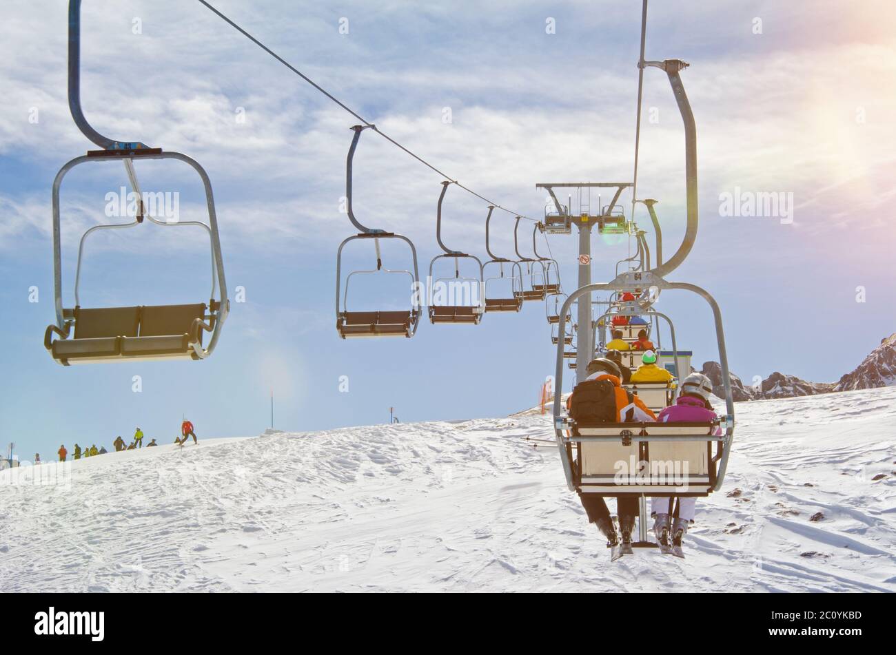 People riding a chairlift in a ski resort in winter Stock Photo