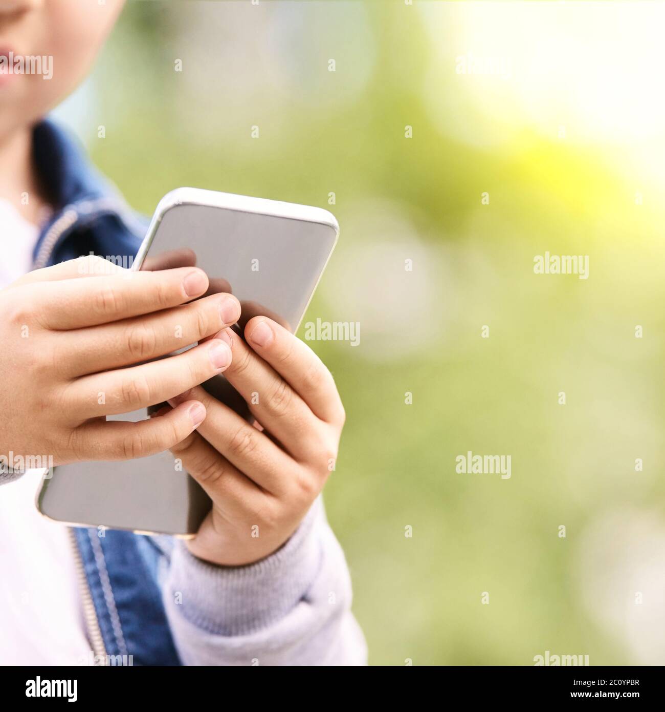 Young school boy texting outdoor. Male person using smartphone. Little ...
