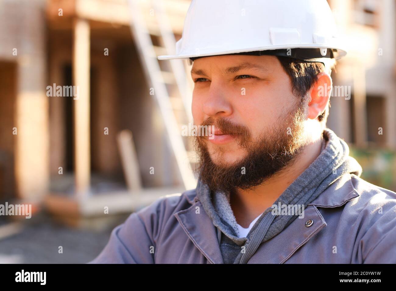 Close up portrait of construction manager and builder wearing hardhat. Stock Photo