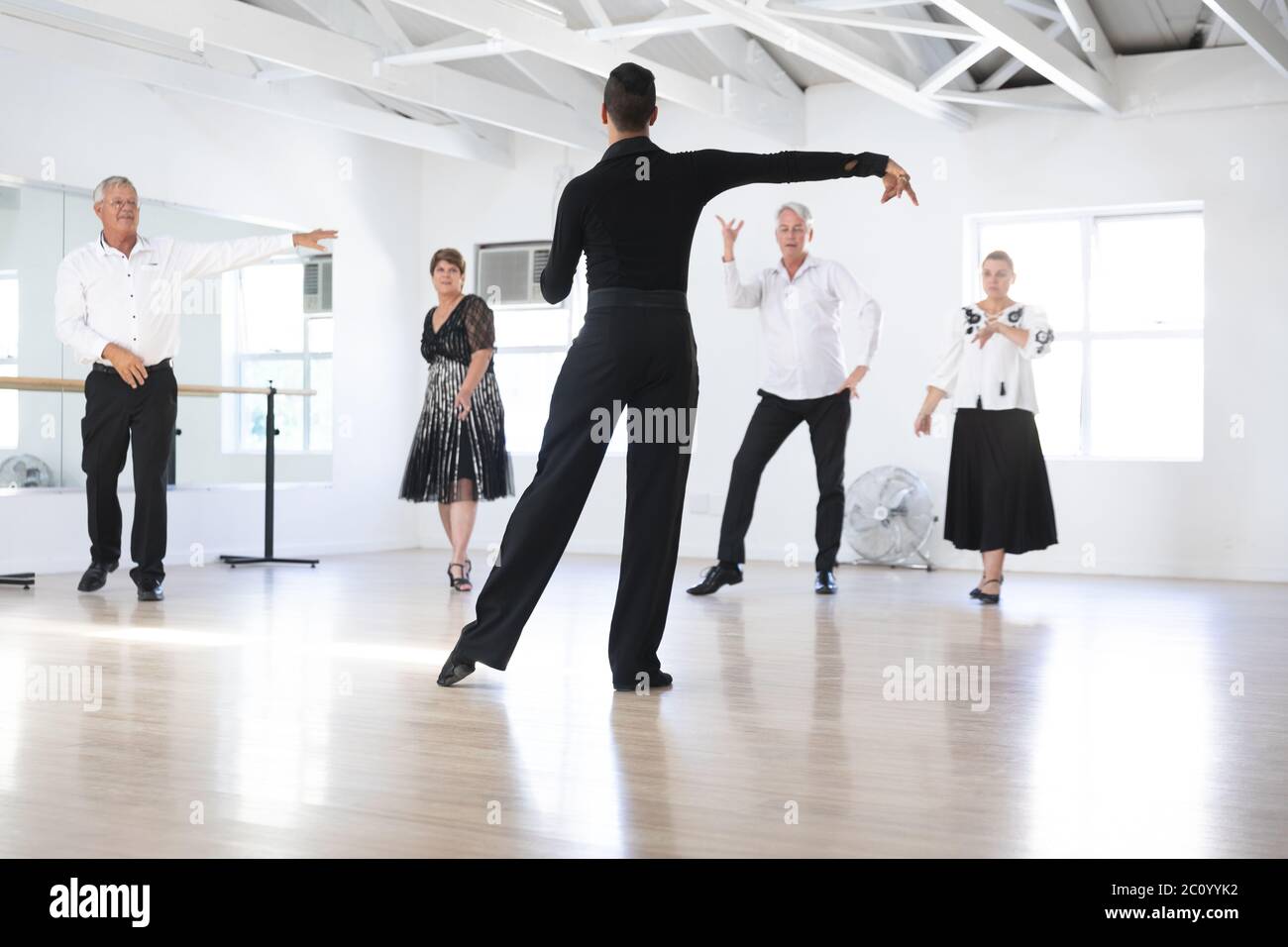 Mixed race dance teacher demonstrating ballroom dancing Stock Photo