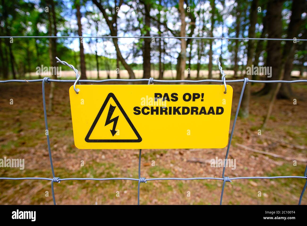 Steal electric safety fence with yellow danger sign written in Dutch Stock Photo