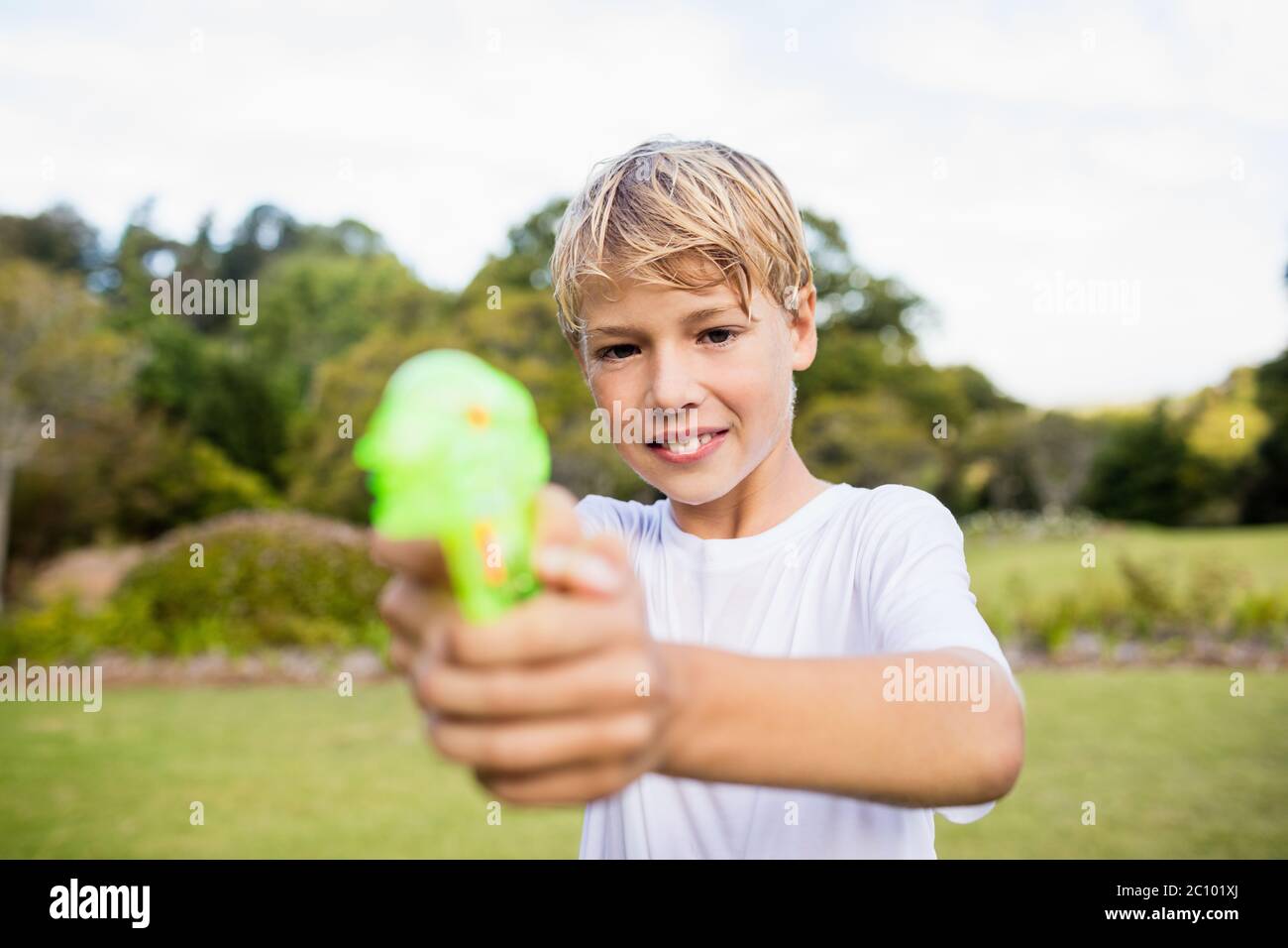 Kid posing at camera during a sunny day with his water gun Stock Photo