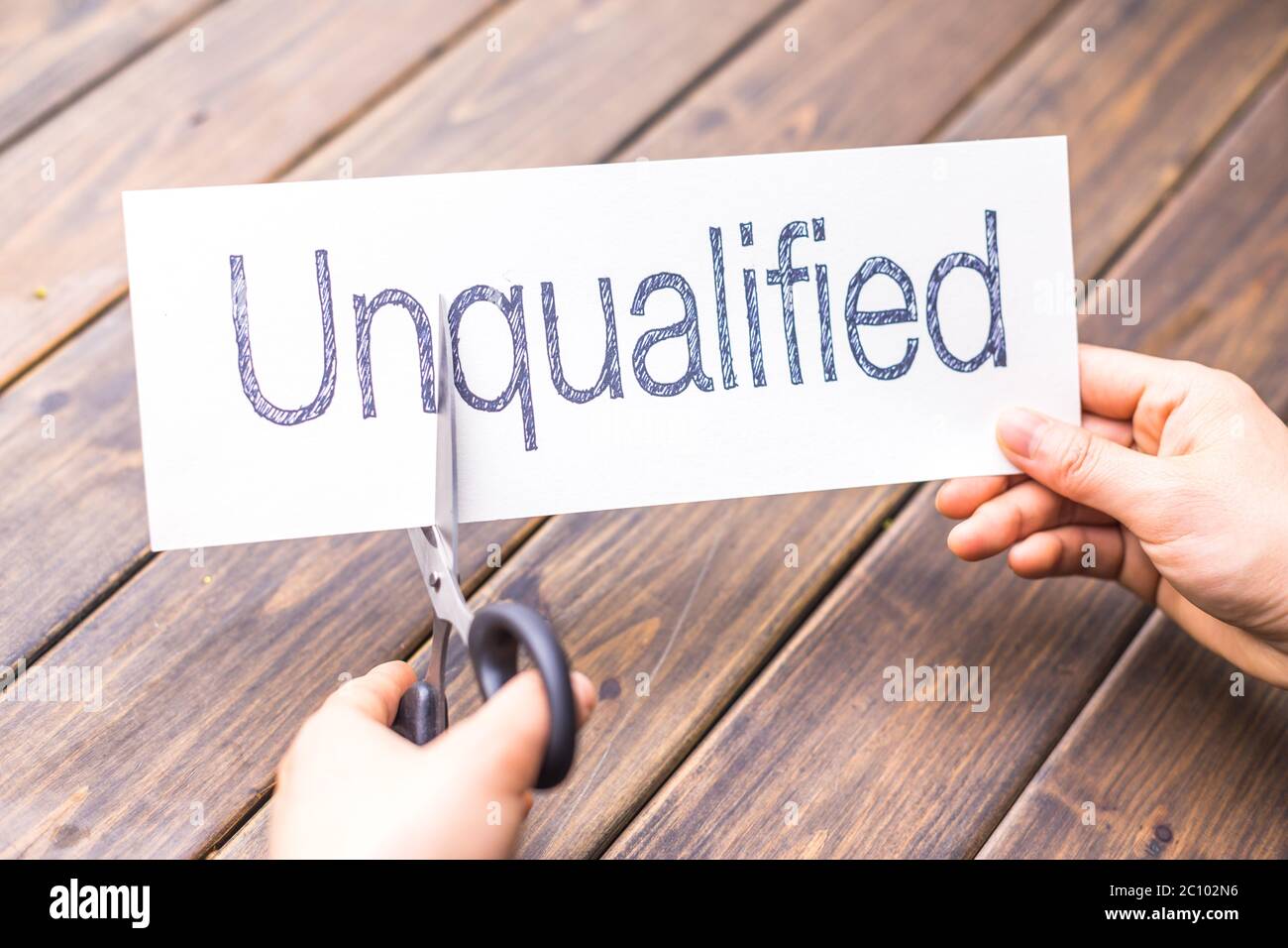 unqualified to qualified on paper by scissors Stock Photo