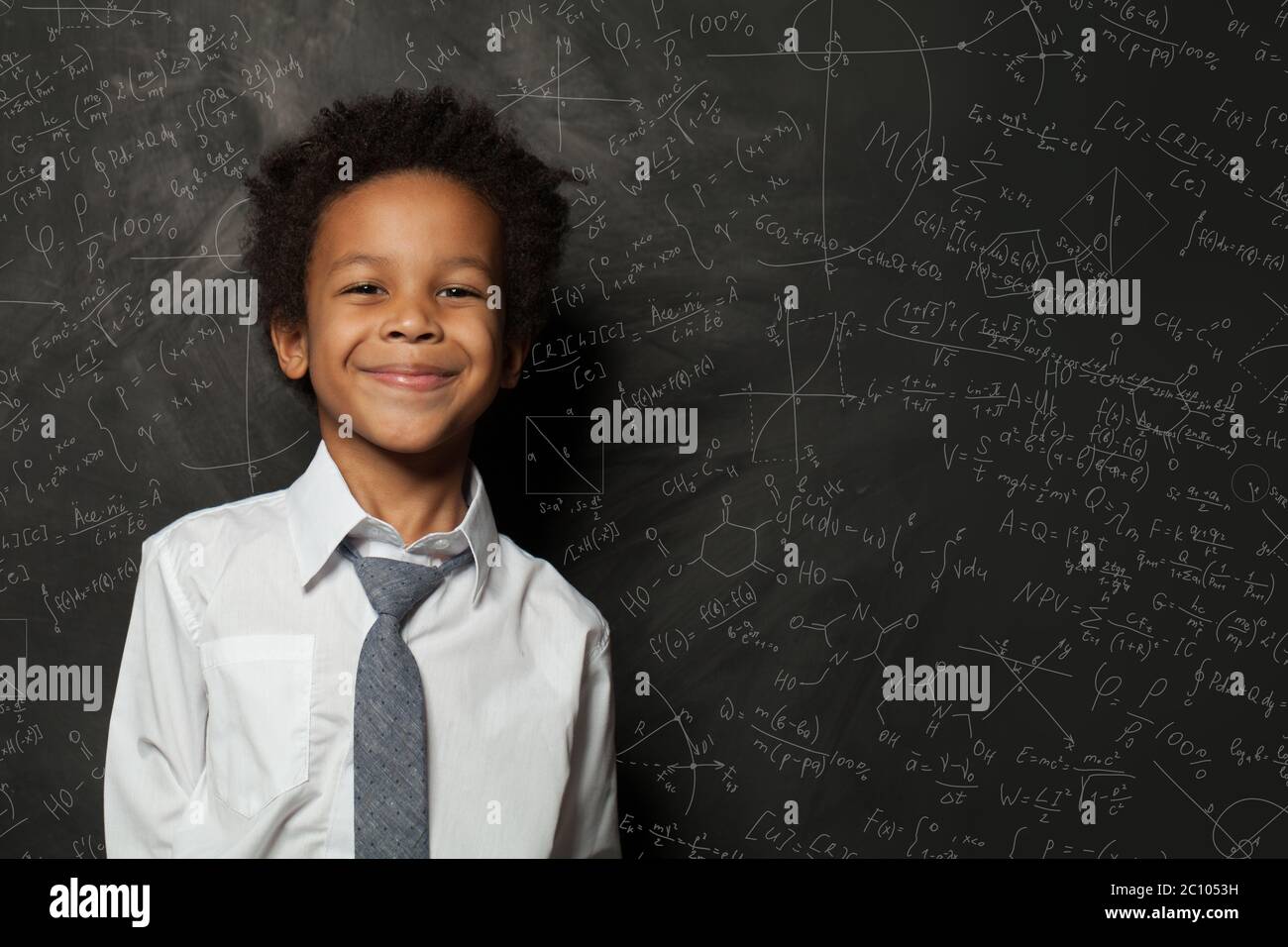 Smart kid student boy on chalkboard background with science formulas ...