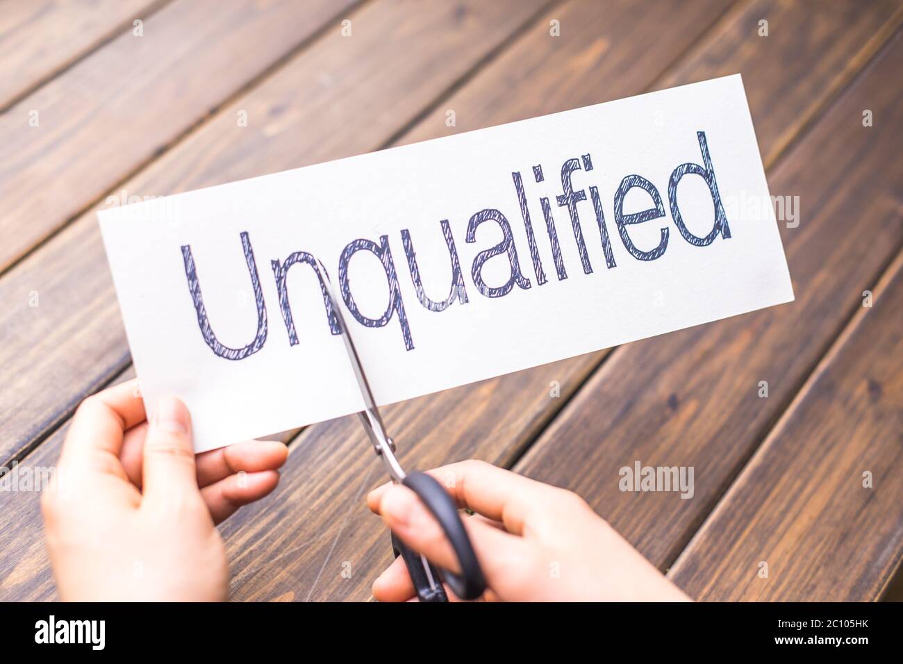unqualified to qualified on paper by scissors Stock Photo