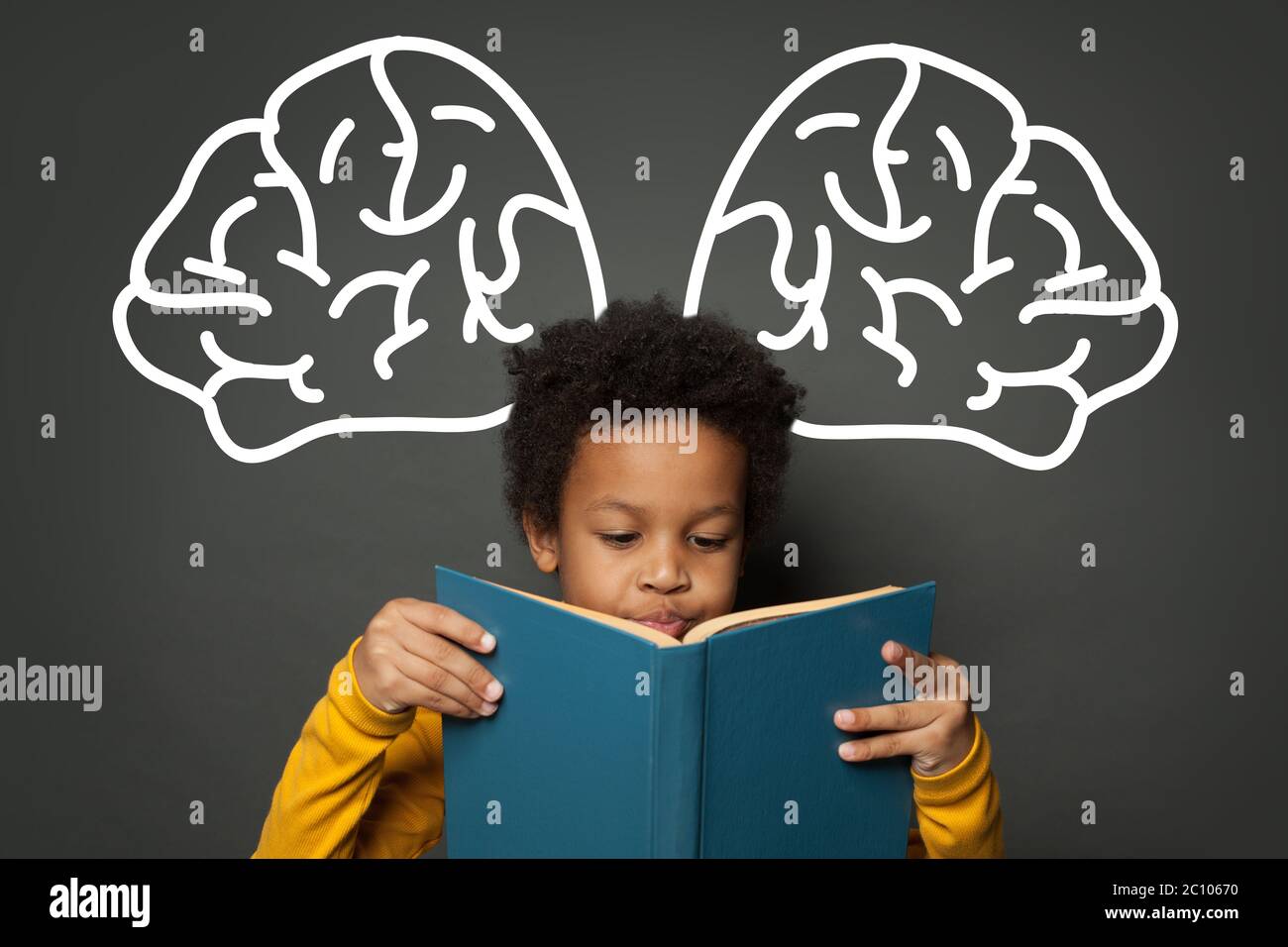 Cute black child reading book on chalkboard background, education concept Stock Photo