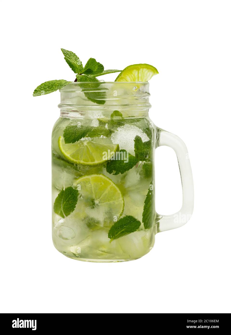 Close up one full big mason jar glass of mojito cocktail with mint leaves, lime slices and ice cubes, isolated on white background, low angle side vie Stock Photo