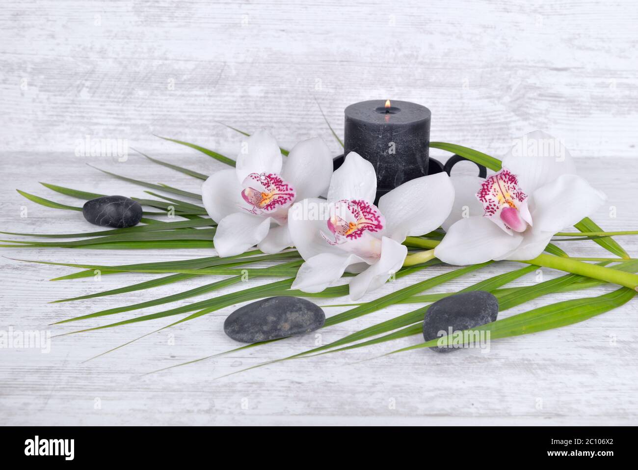 arrangement on white table with orchid, pebbles and candle Stock Photo