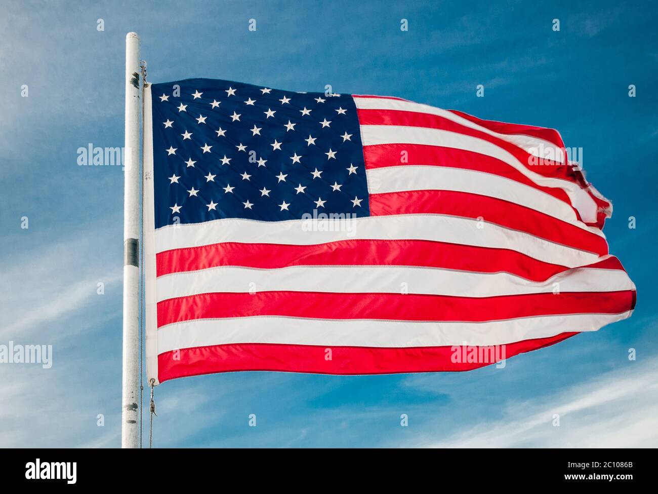 American flag against bright blue sky Stock Photo - Alamy