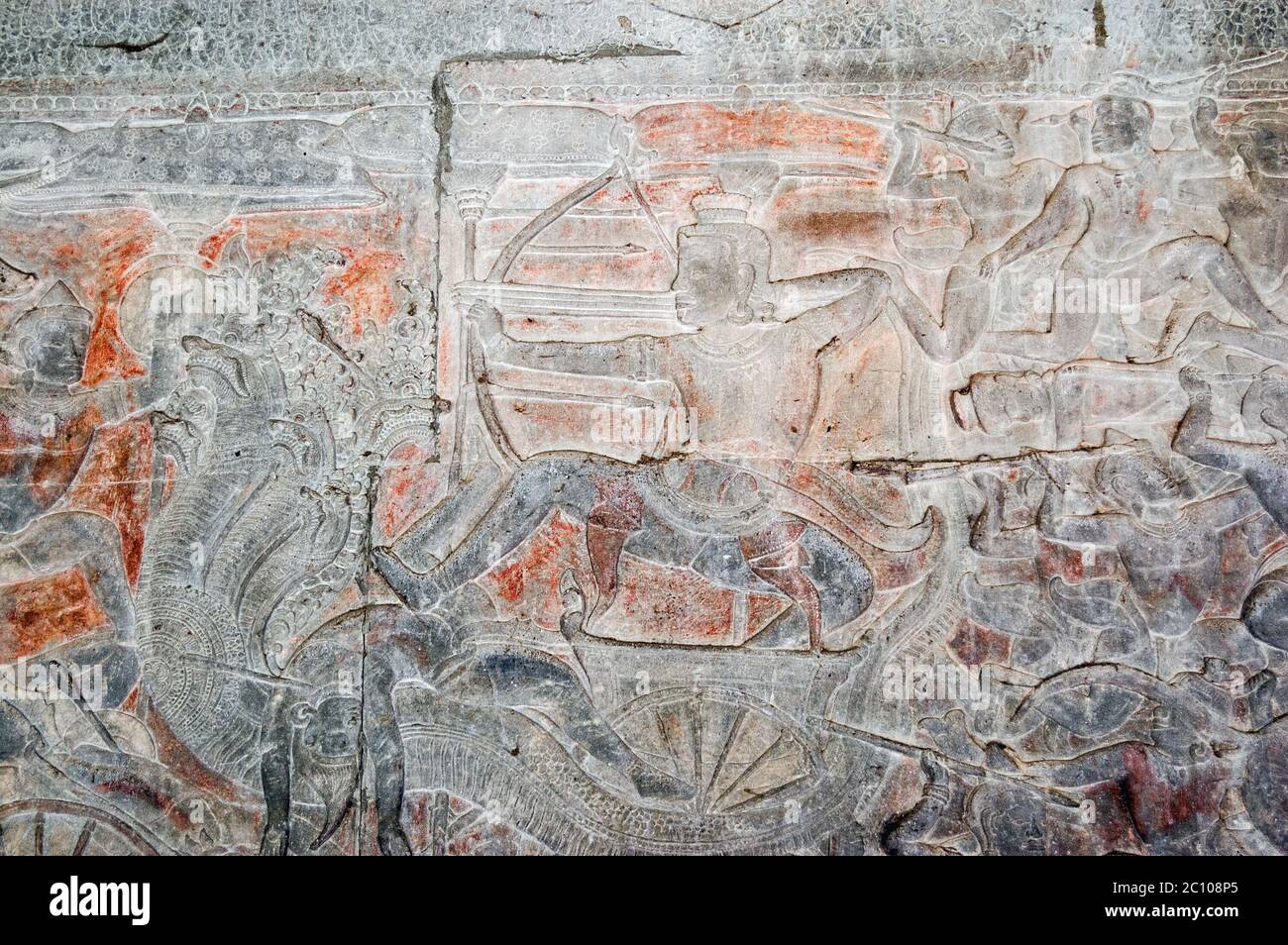 Ancient Khmer bas relief carving showing the Hindu god Shiva firing an arrow from a chariot pulled by a Naga - a many headed snake god. Wall of Angkor Stock Photo