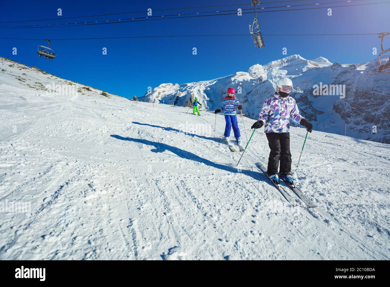 Three Kids Ski On The Alpine Slope As Part Of The School Group One After Another With Mountains And Lift On Background Stock Photo Alamy