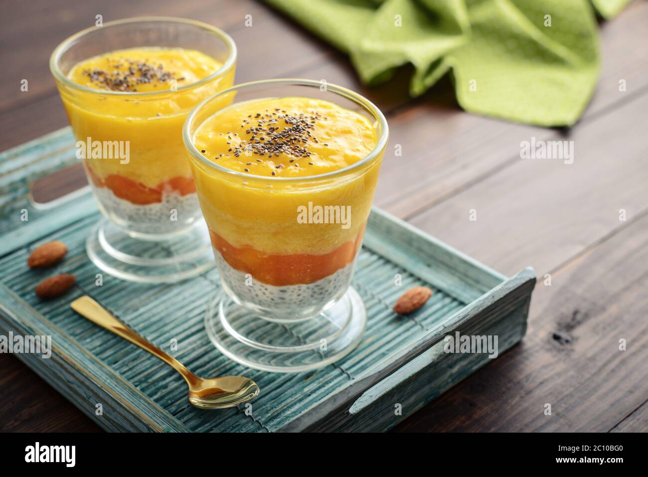 Homemade chia seed pudding with mango and almond in glass on wooden background Stock Photo