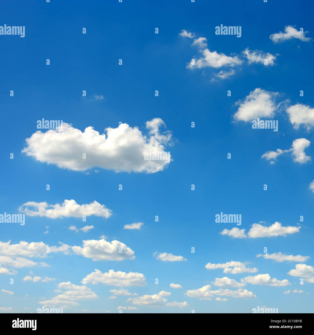 Fluffy clouds on bright blue sky background Stock Photo - Alamy