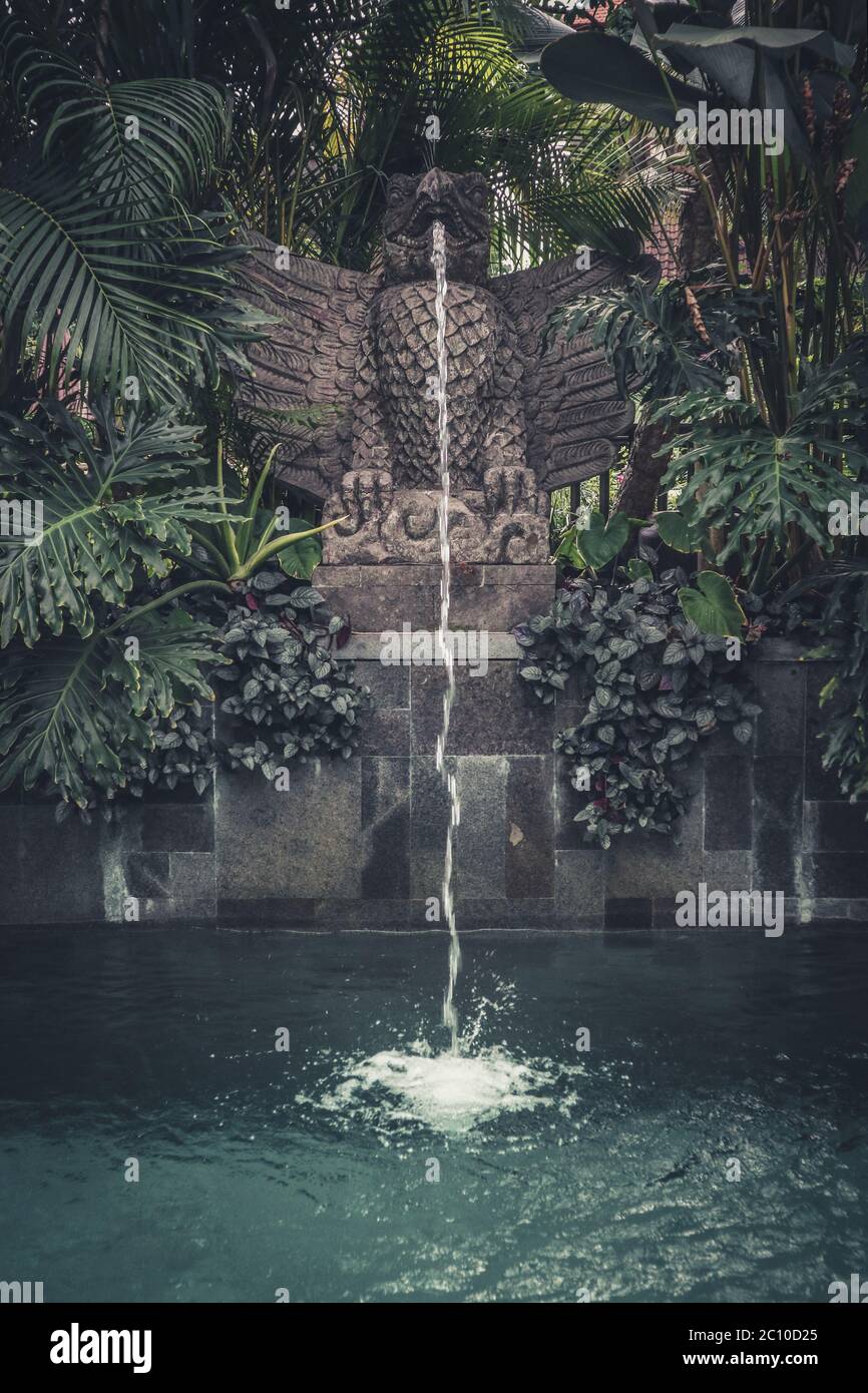 Swimming pool with traditional balinese decorative fountain in shape of ...