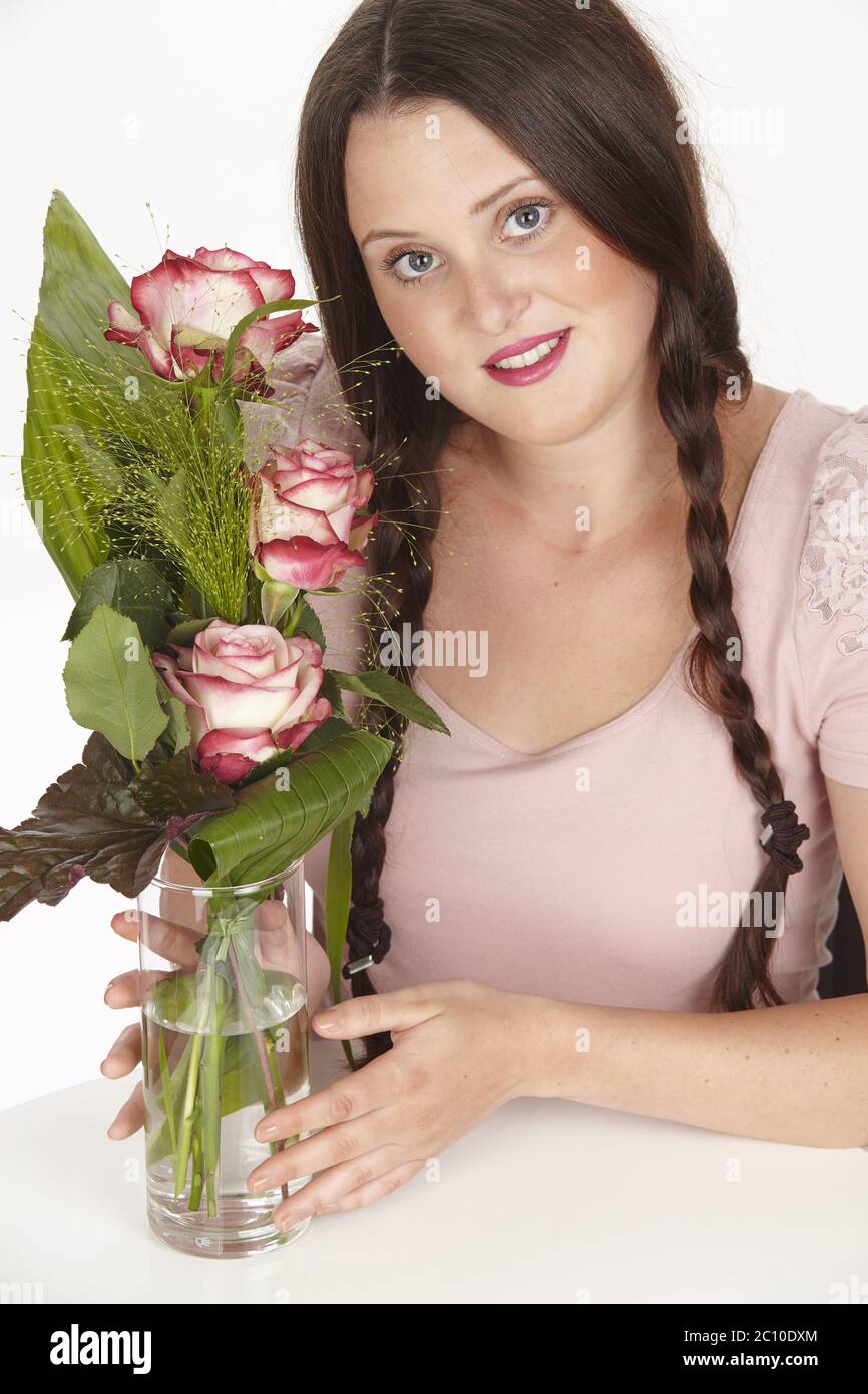 Young brunette woman with plaits and bouquet of flowers (roses) Stock Photo