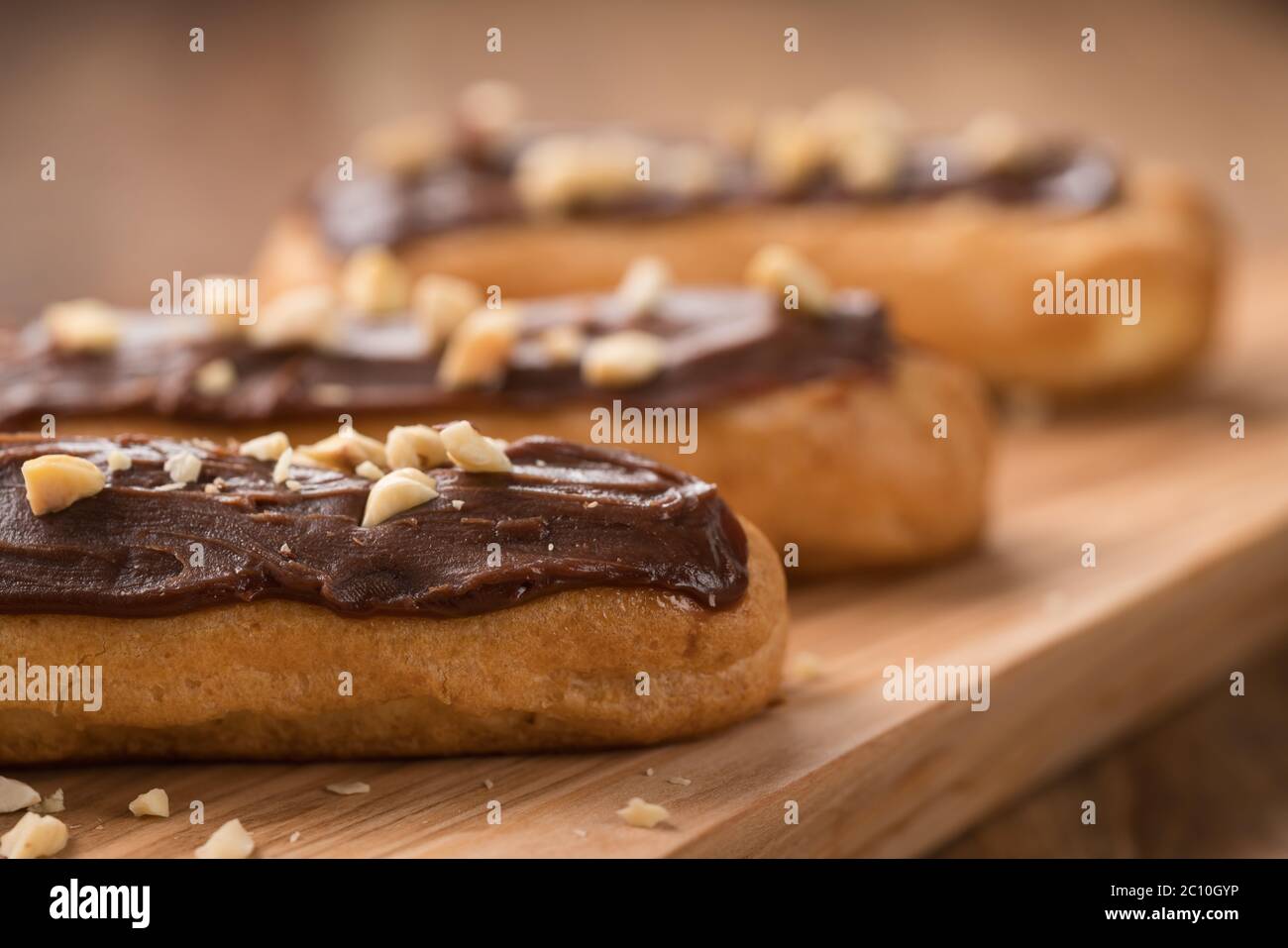 french eclairs with choclate top and hazelnuts closeup Stock Photo