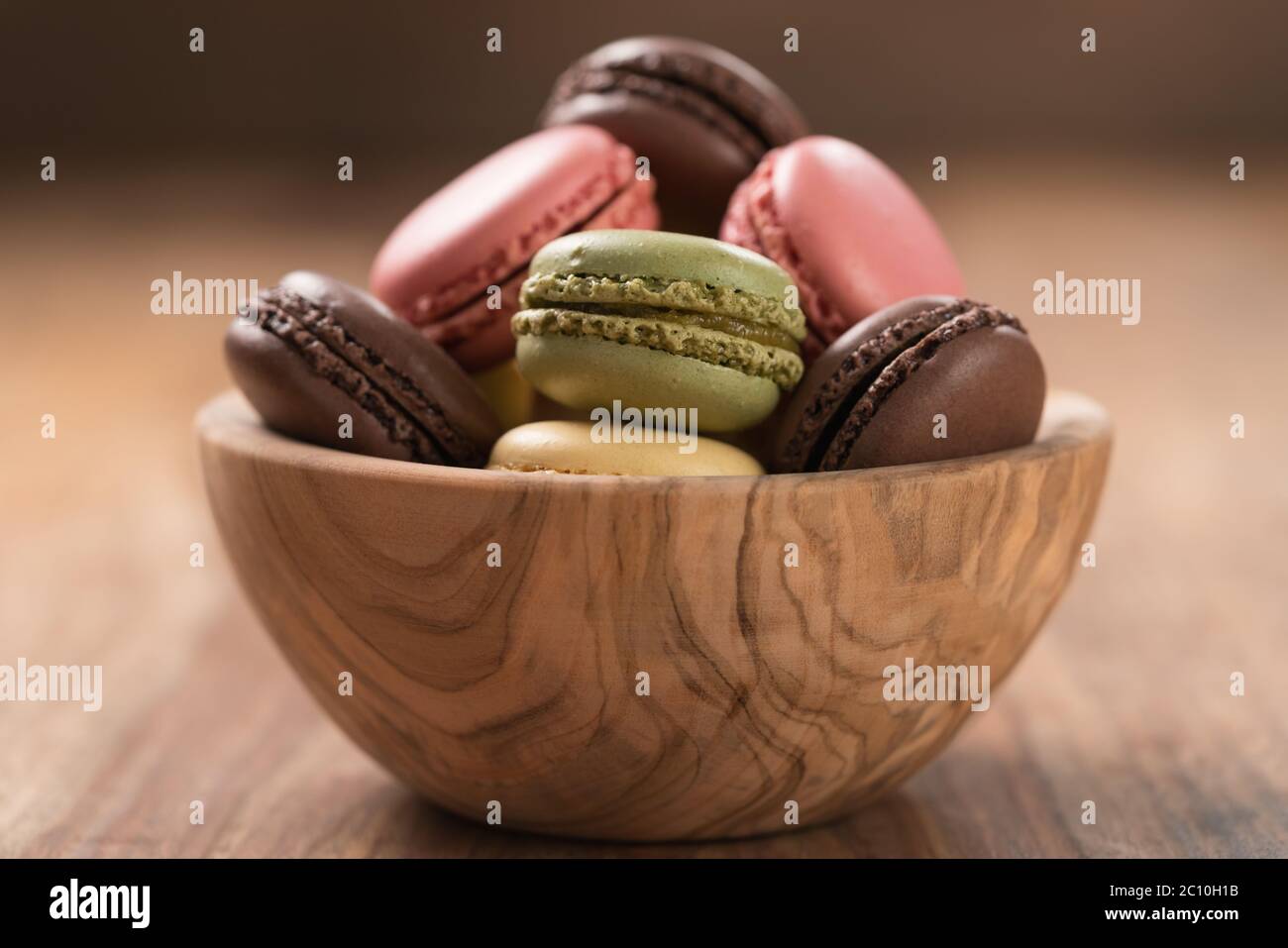 Various french macarons in olive wood bowl closeup Stock Photo