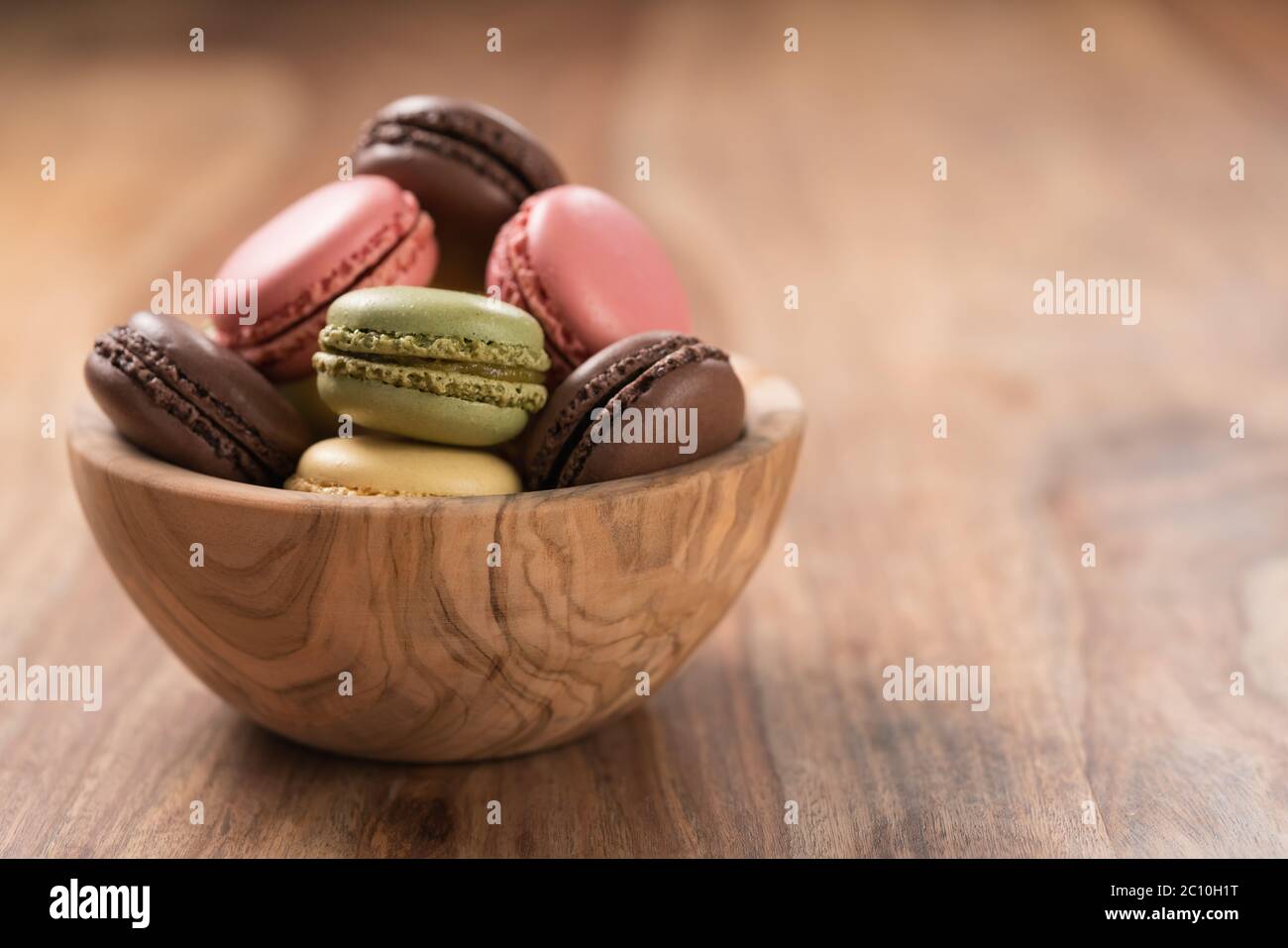 Various french macarons in olive wood bowl with copy space Stock Photo