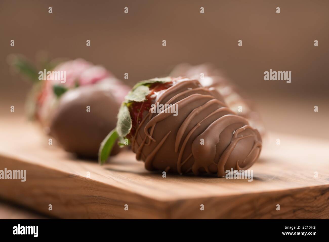 Chocolate covered fresh strawberry on wood background Stock Photo