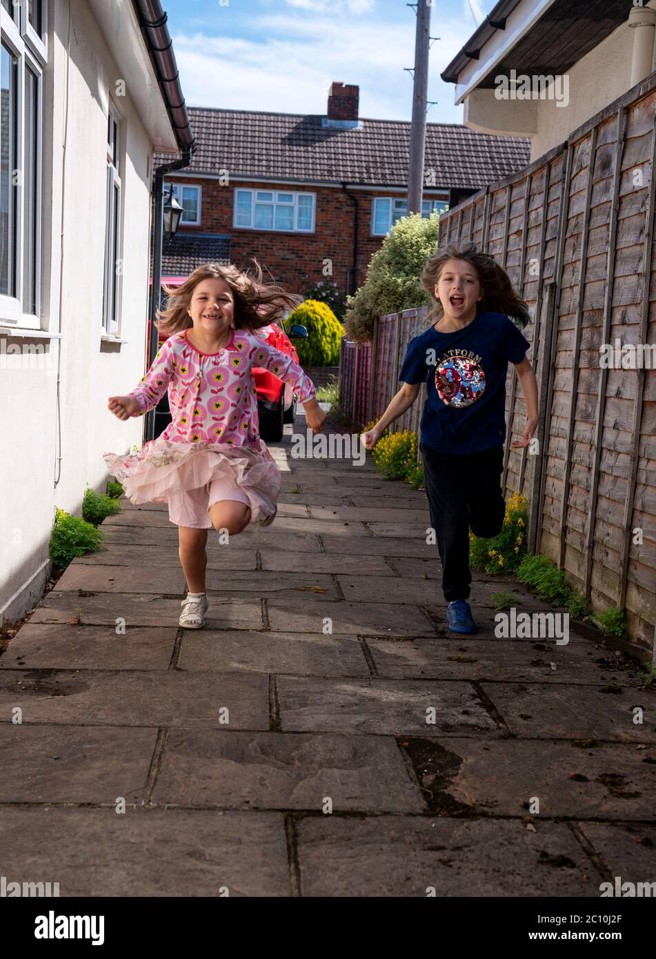 Emily (right) and Daisy running to see their grandma in Ashtead, Surrey, for the first time following the introduction of measures to bring England out of lockdown, as people living alone in England can form support bubbles with other households from Saturday, ending weeks of isolation under lockdown. Stock Photo