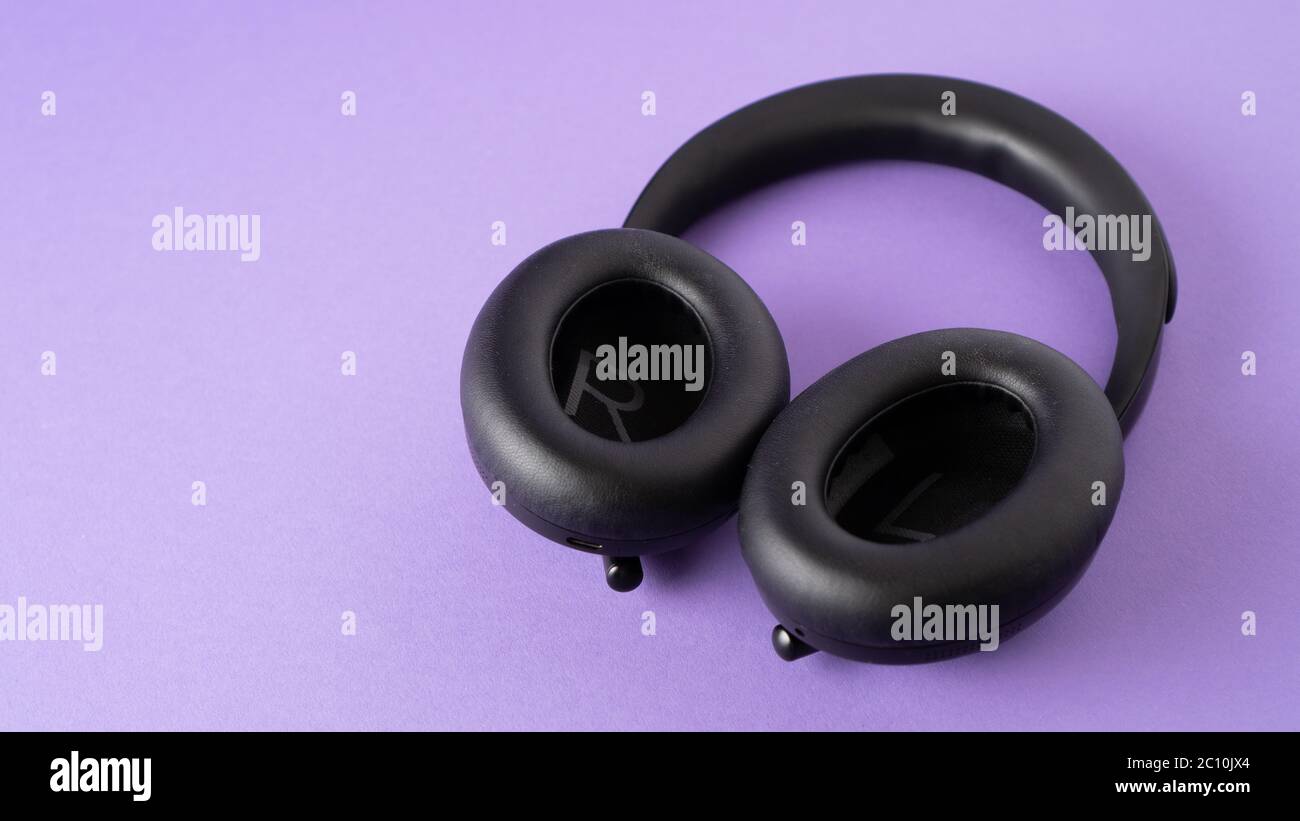 black wireless headphones on violet background. lifts the mood and inspires. headphone advertising. copy space. High quality photo Stock Photo