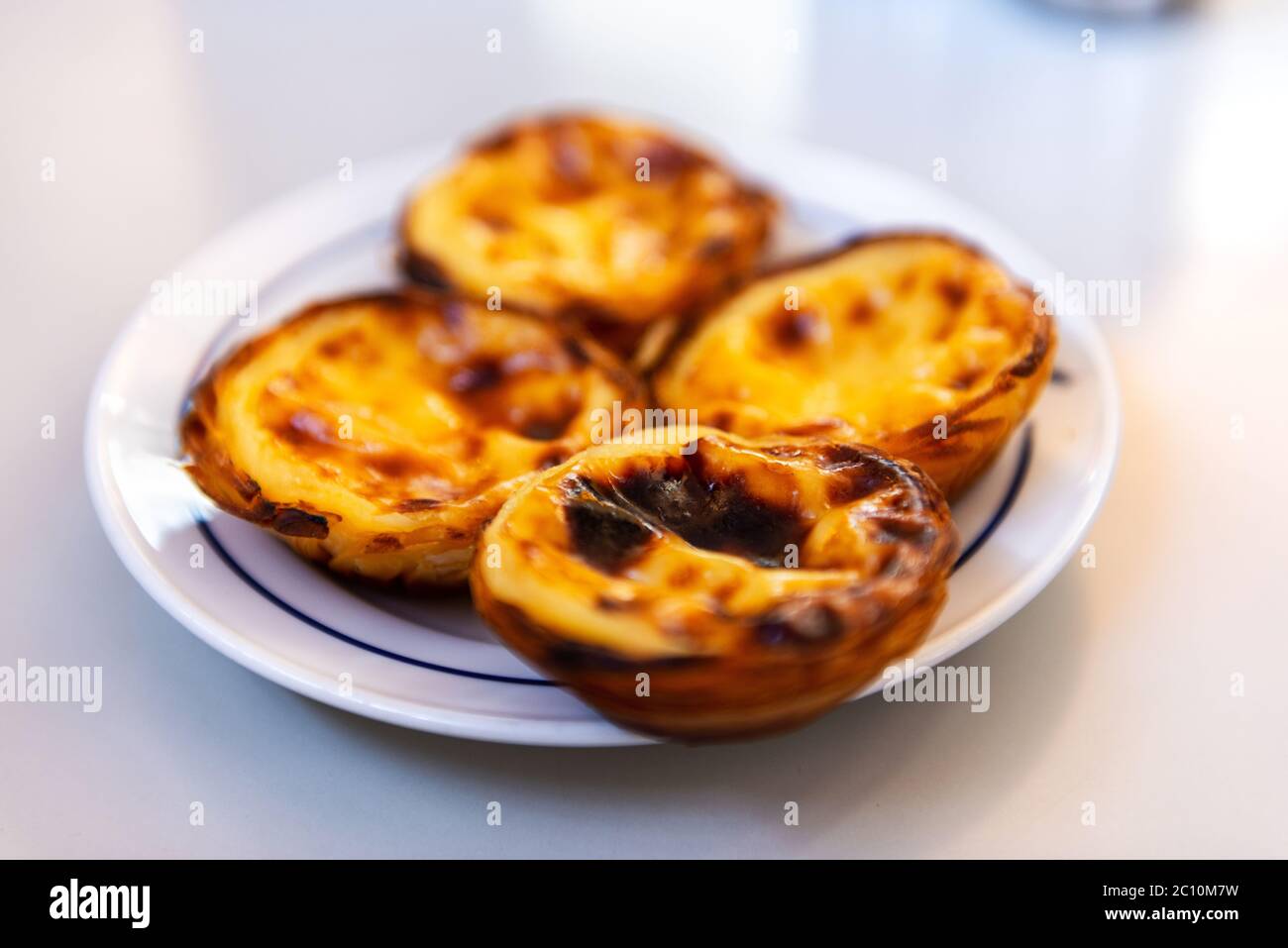 Fresh Pasteis de Belem (typical Portuguese egg tarts) just backed in a local bakery in Lisbon. Stock Photo